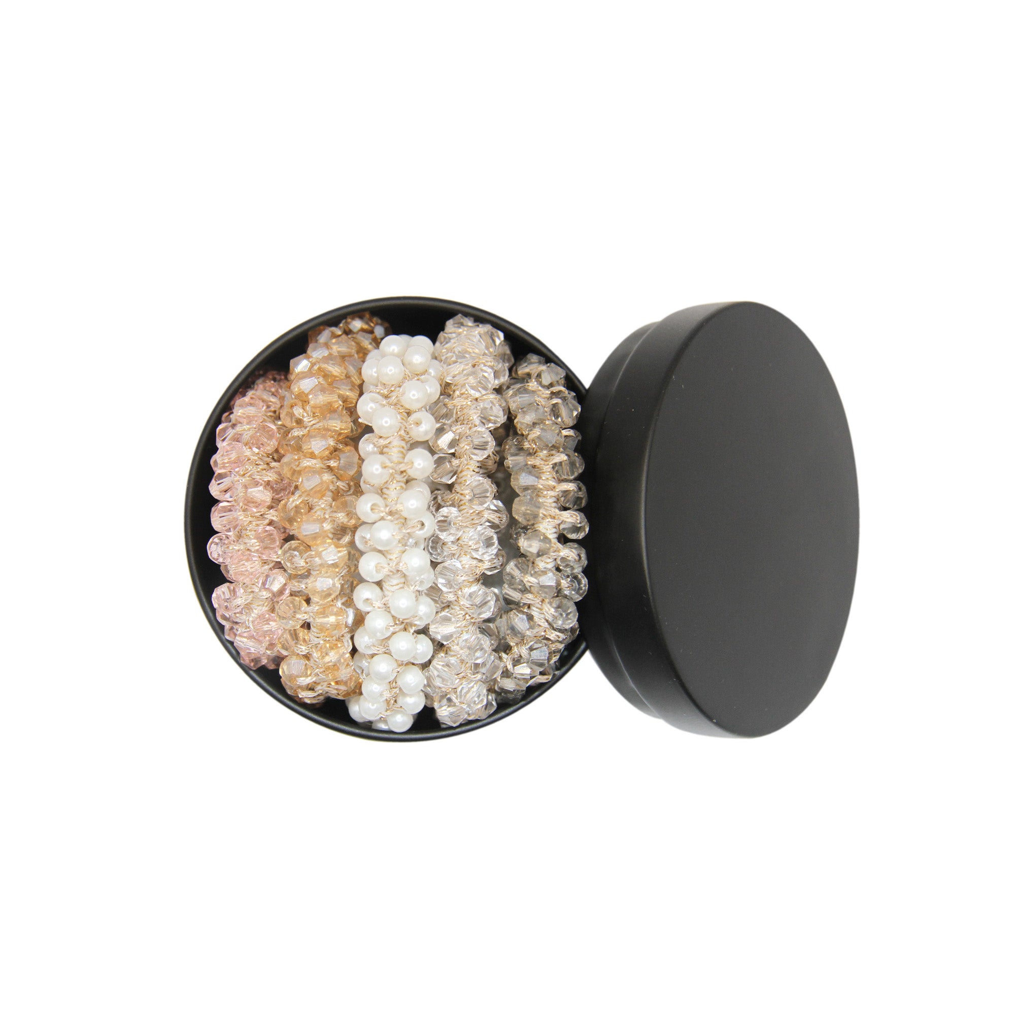 Set of beaded hair ties in a black tin on a white background