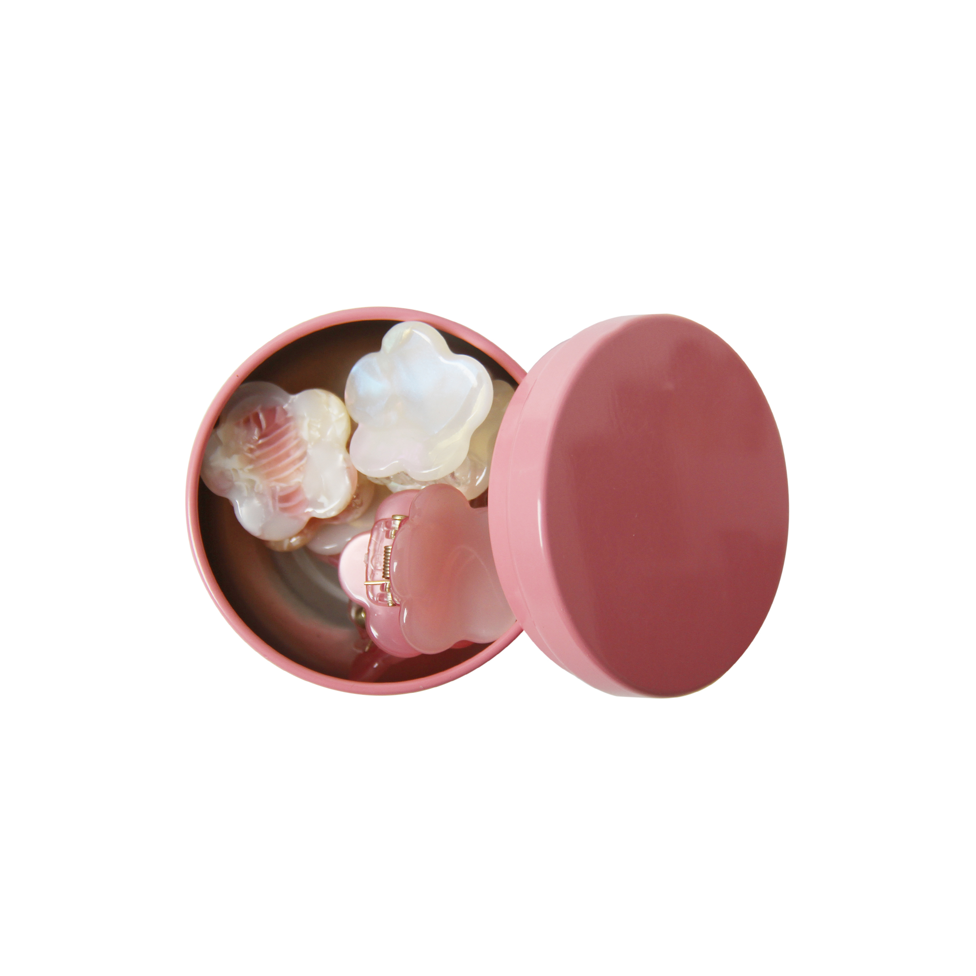 set of six pink hair claws in a open pink tin on a white background