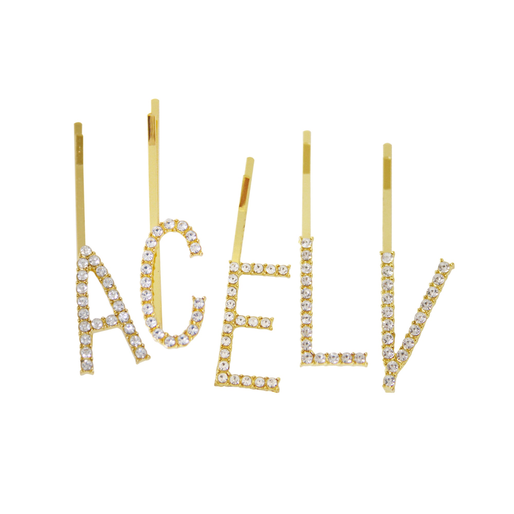 A group of gold and crystal letter hair slides on a white background, a letter 'A' crystal hair slide, a letter 'C' crystal hair slide, a letter 'E' crystal hair slide, a letter 'L' crystal hair slide and a letter 'V' crystal hair slide