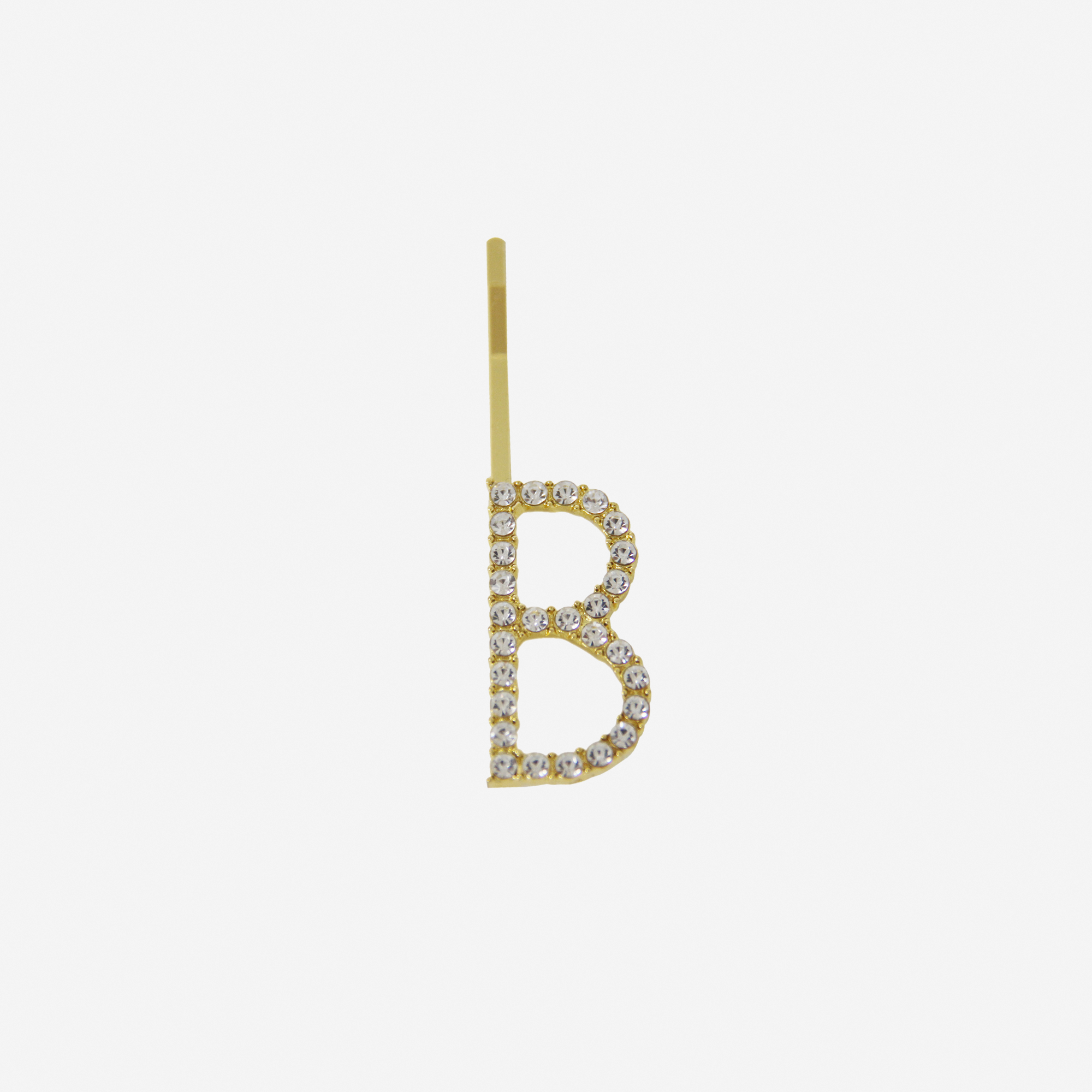 Gold and crystal hair slide featuring the letter 'B' on an off white background