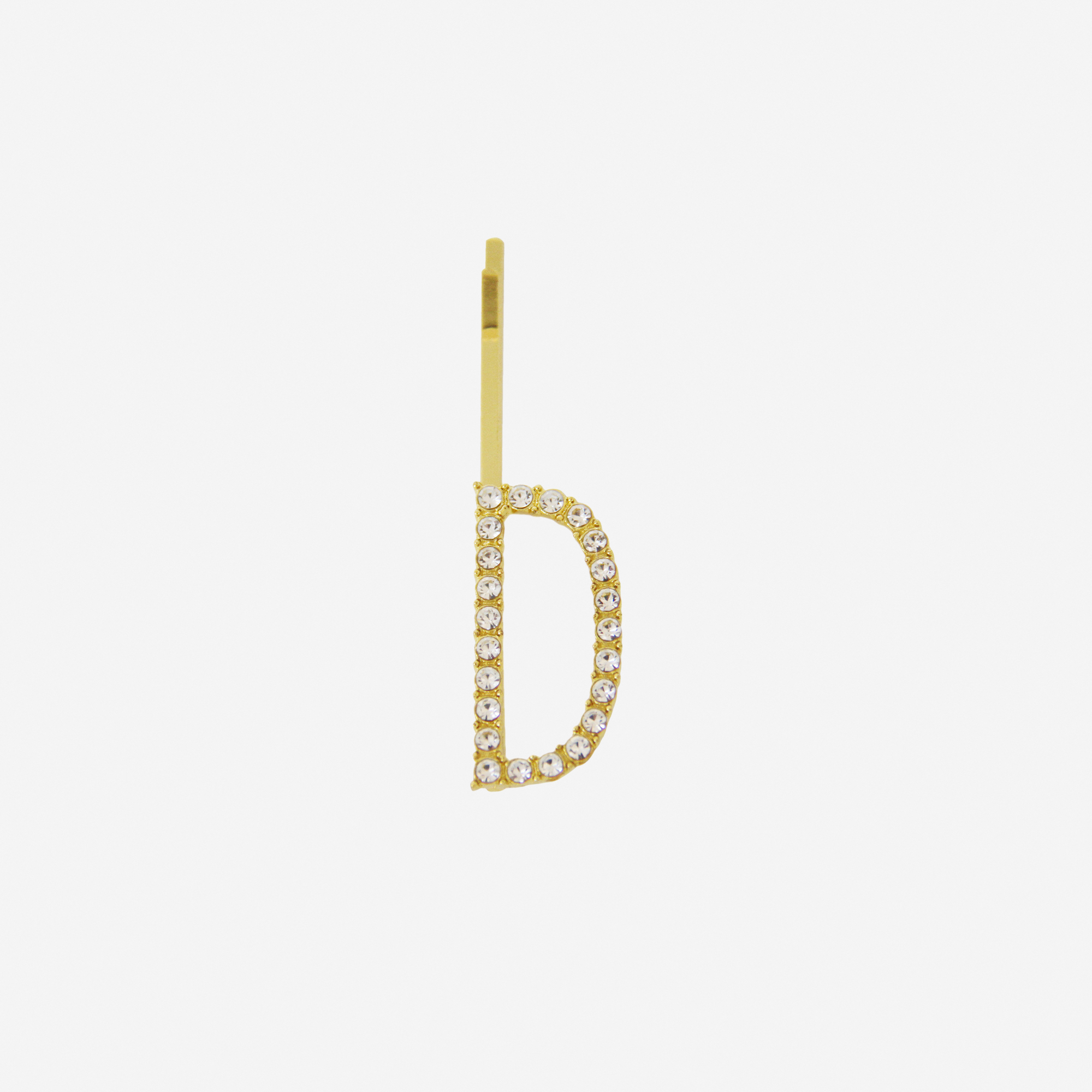 Gold and crystal hair slide featuring the letter 'D' on an off white background