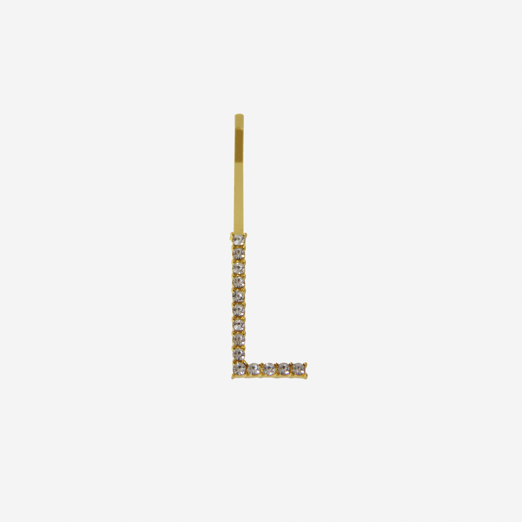 Gold and crystal hair slide featuring the letter 'L' on an off white background