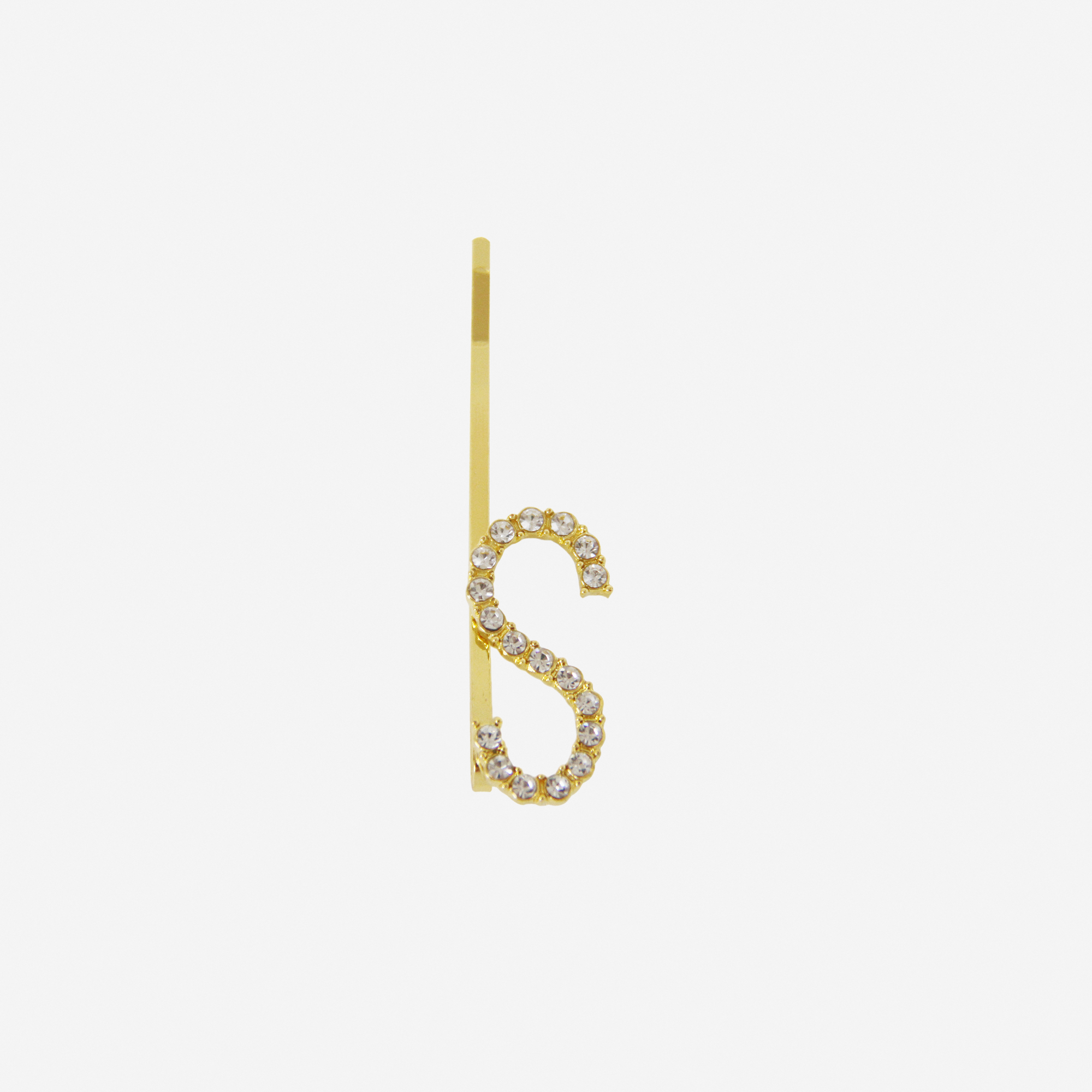 Gold and crystal hair slide featuring the letter 'S' on an off white background