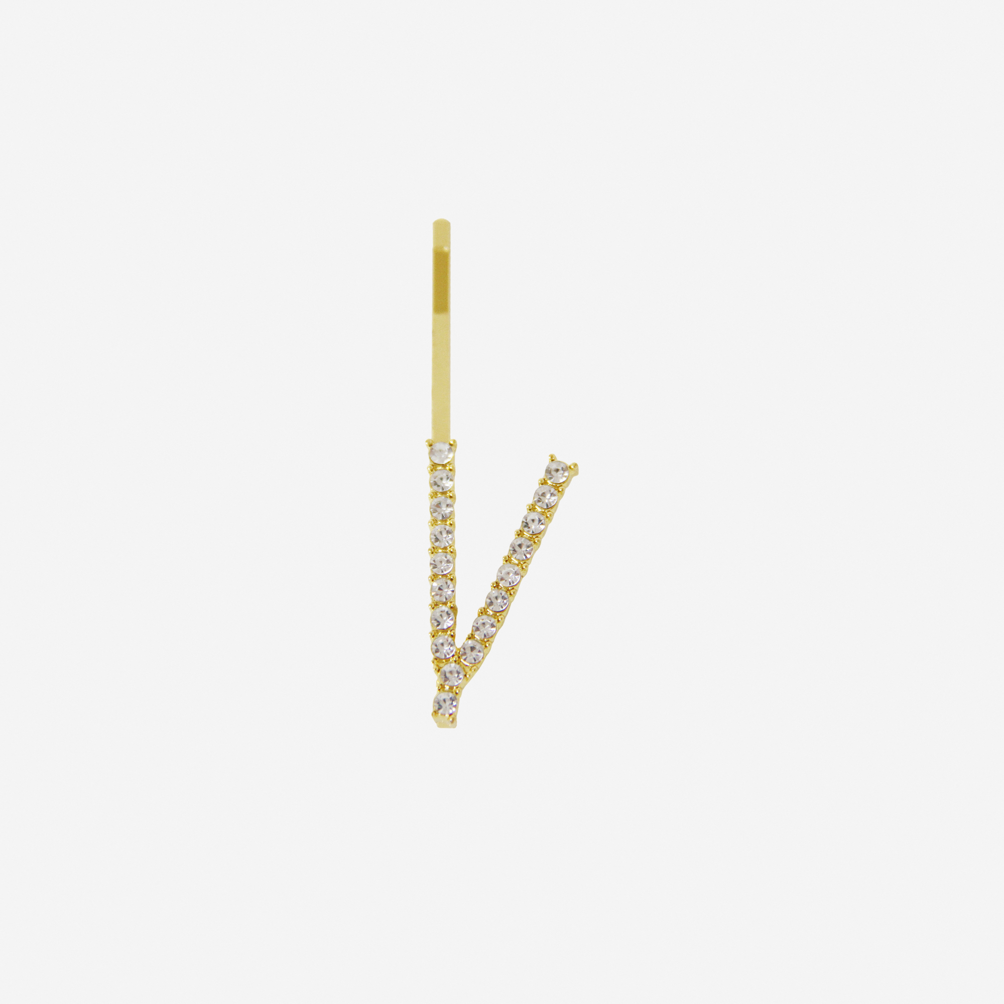Gold and crystal hair slide featuring the letter 'V' on an off white background