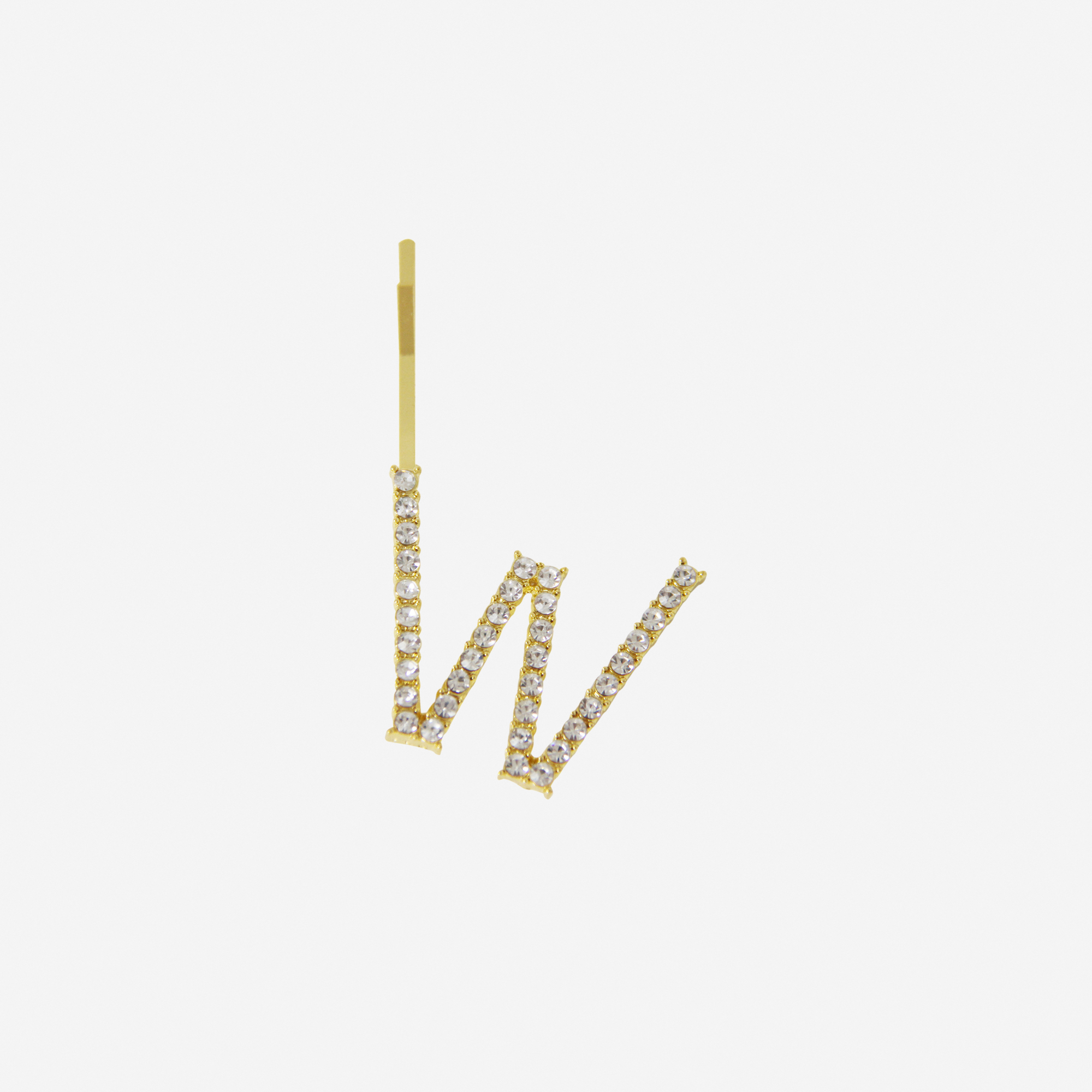 Gold and crystal hair slide featuring the letter 'W' on an off white background