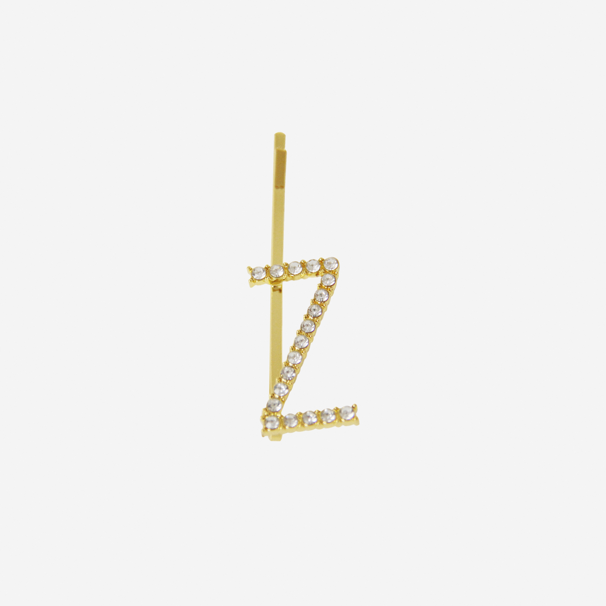 Gold and crystal hair slide featuring the letter 'Z' on an off white background