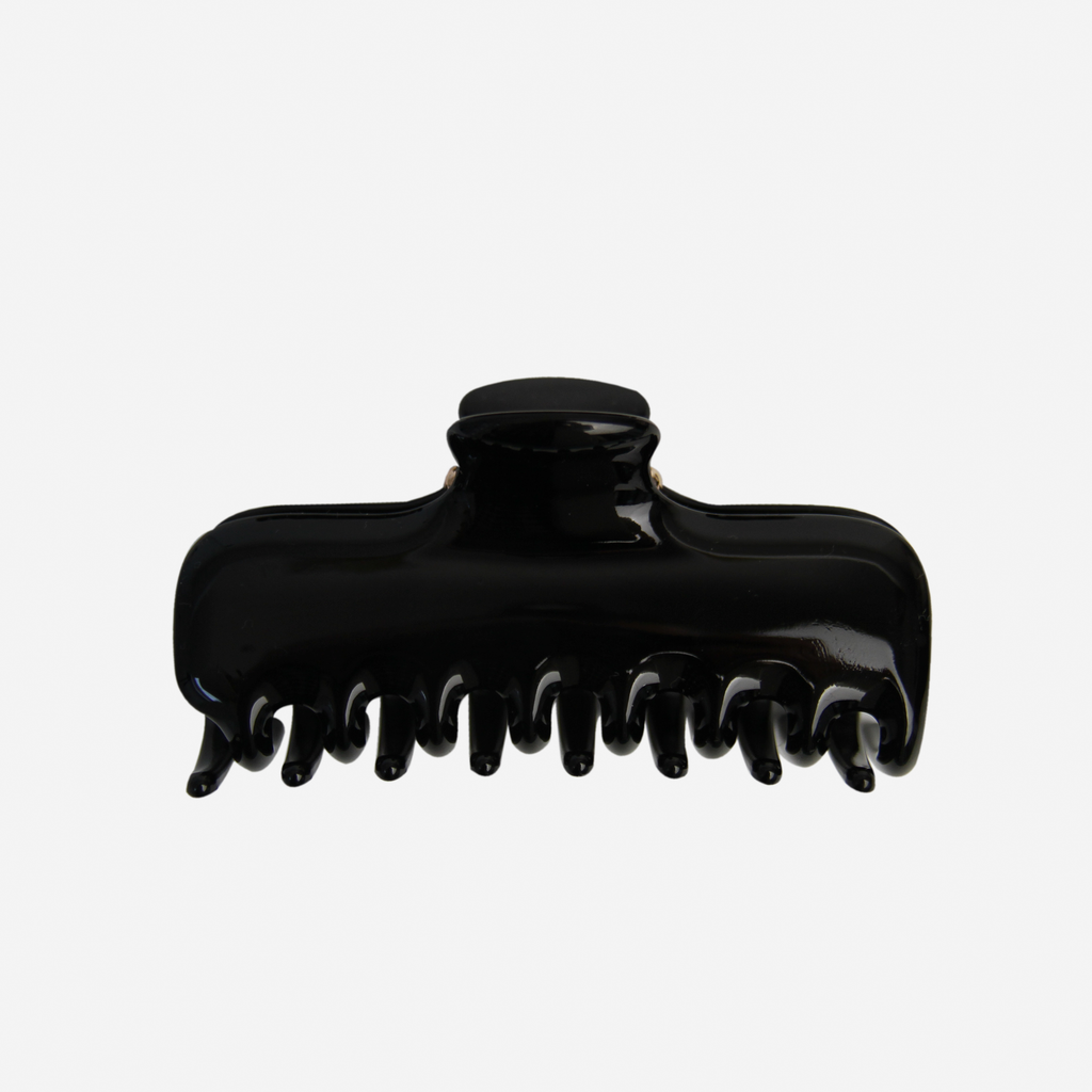 Large black hair claw on an off white background