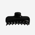 Large black hair claw on an off white background