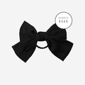 Black hair bow hair tie on an off white background