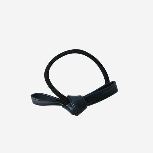 Navy blue faux leather bow on a black hair elastic