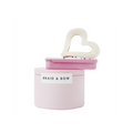Braid & Bow gift set, showing a stack of tins containing silk scrunchies and non crease hair clips with a cream heart hair claw balanced on top, on a white background