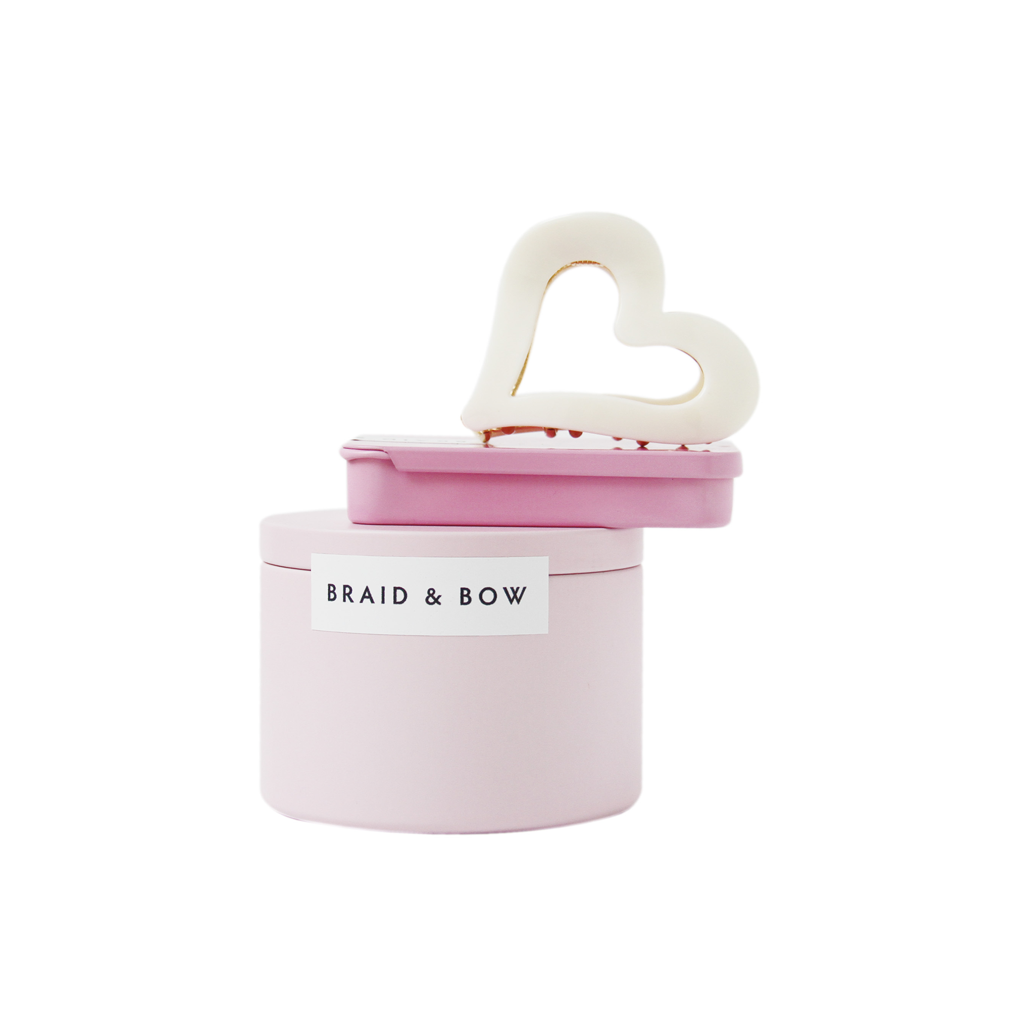 Braid & Bow gift set, showing a stack of tins containing silk scrunchies and non crease hair clips with a cream heart hair claw balanced on top, on a white background