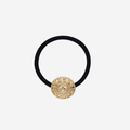 Black hair elastic with a gold decorative vintage inspired button, on an off white background