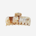 Marbled brown and beige patterned hair claw on an off white background