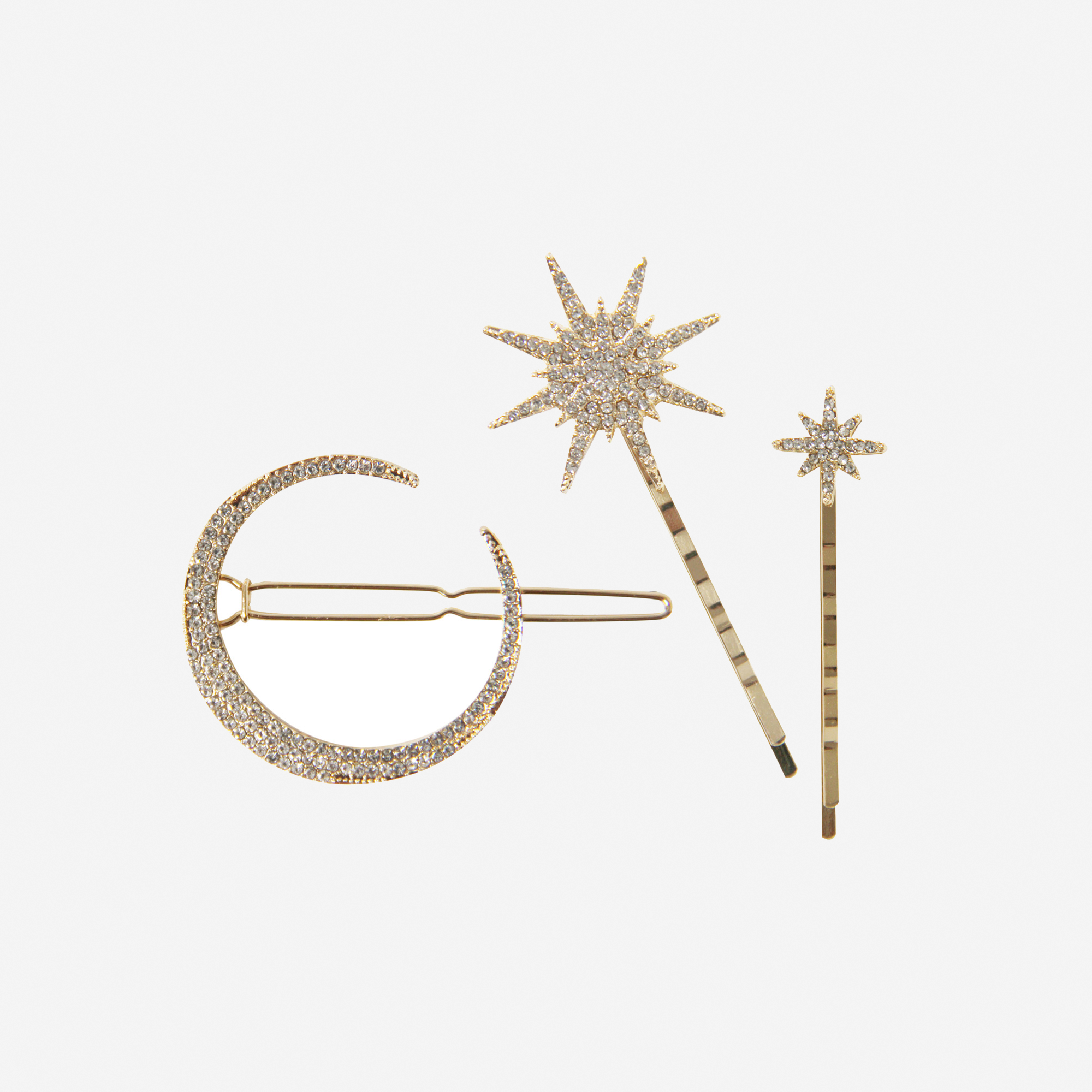 Set of 3 gold and crystal star and moon hair clips on an off white background