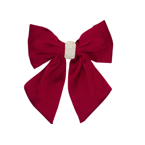 Red hair bow with a crystal pave center on a white background