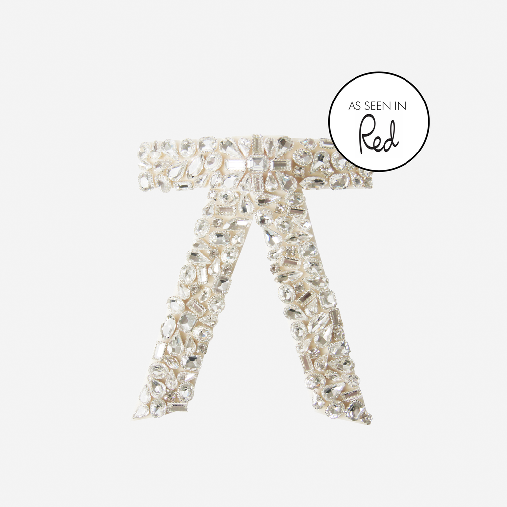 Crystal encrusted cream velvet hair bow on an off white background featuring an as seen in Red magazine logo