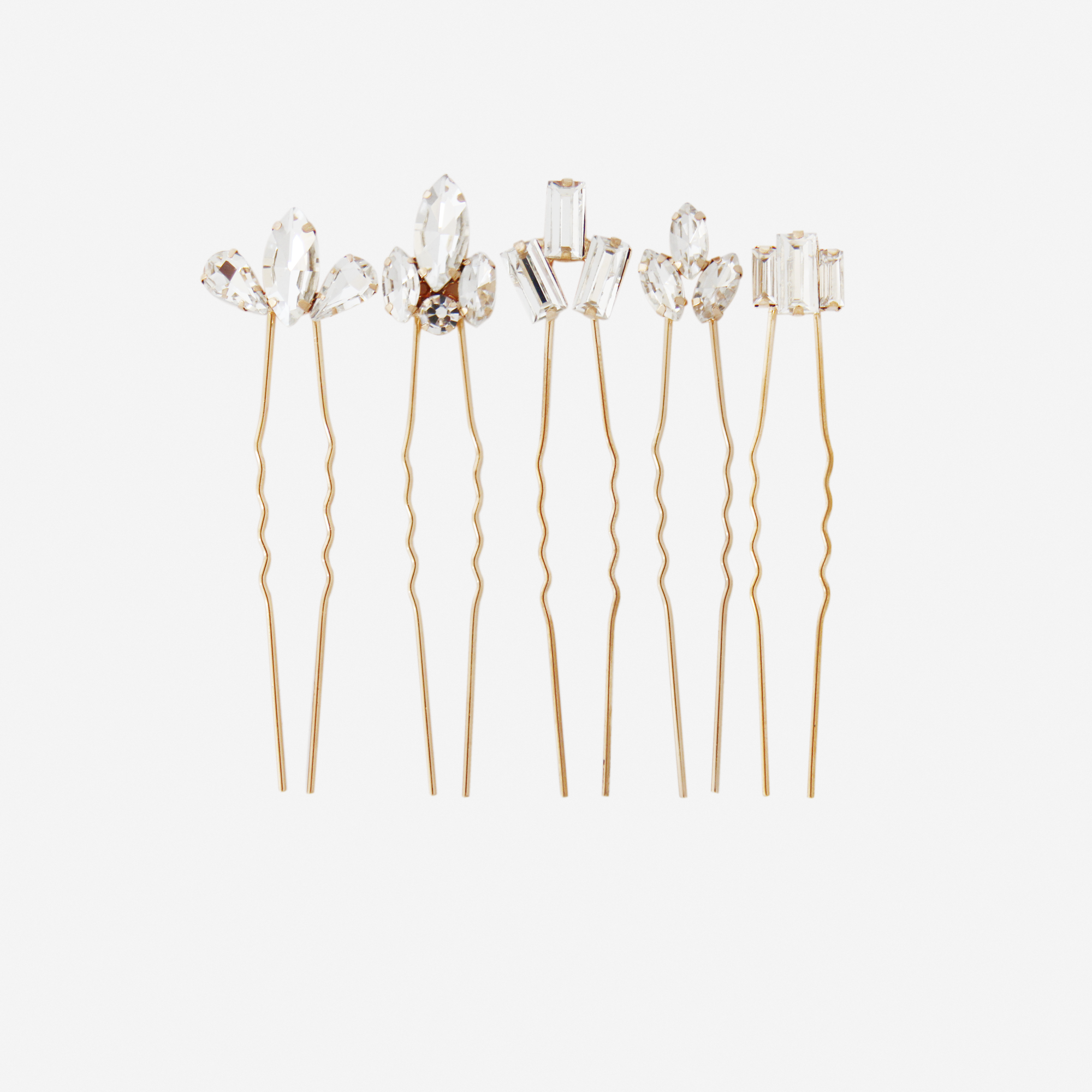 Set of five crystal hair pins with different crystal designs on an off white background