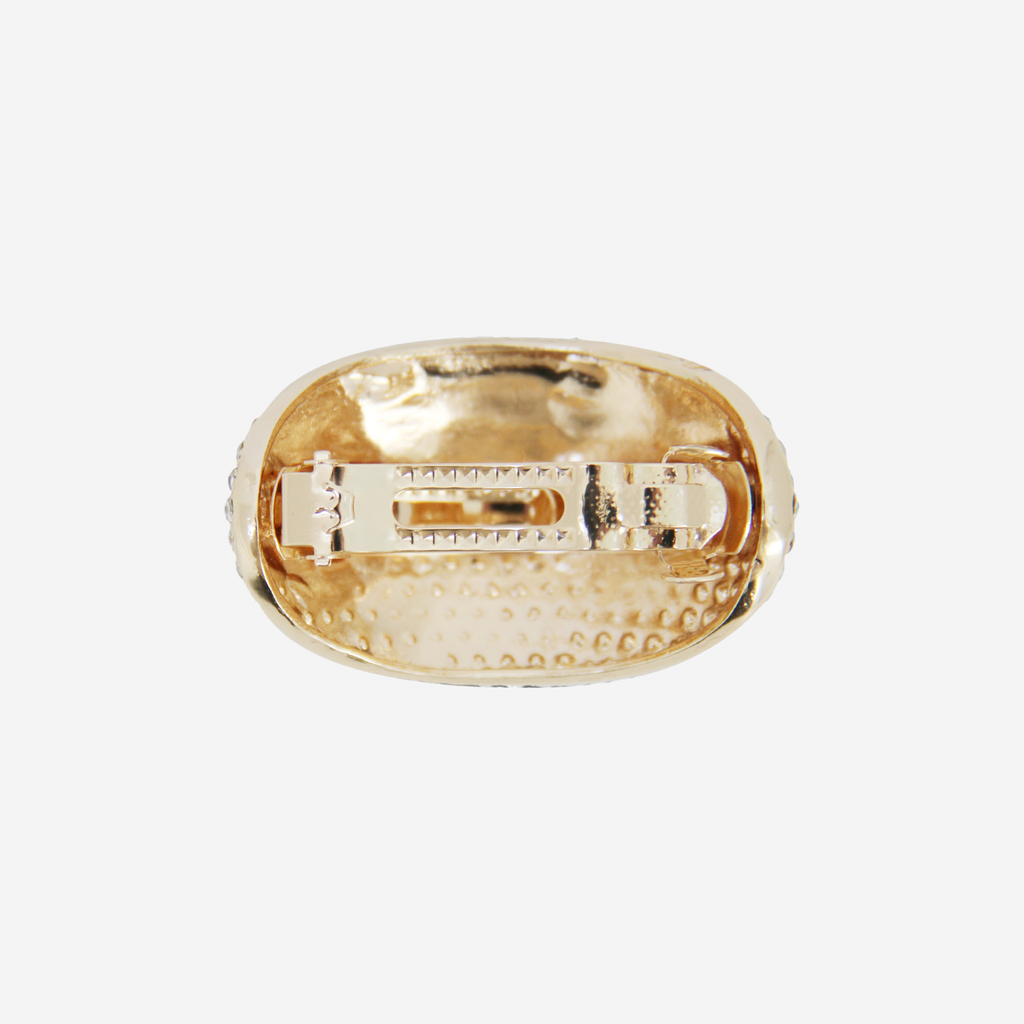 Oval gold and crystal pave ponytail holder,  back view showing the fastening, on an off white background