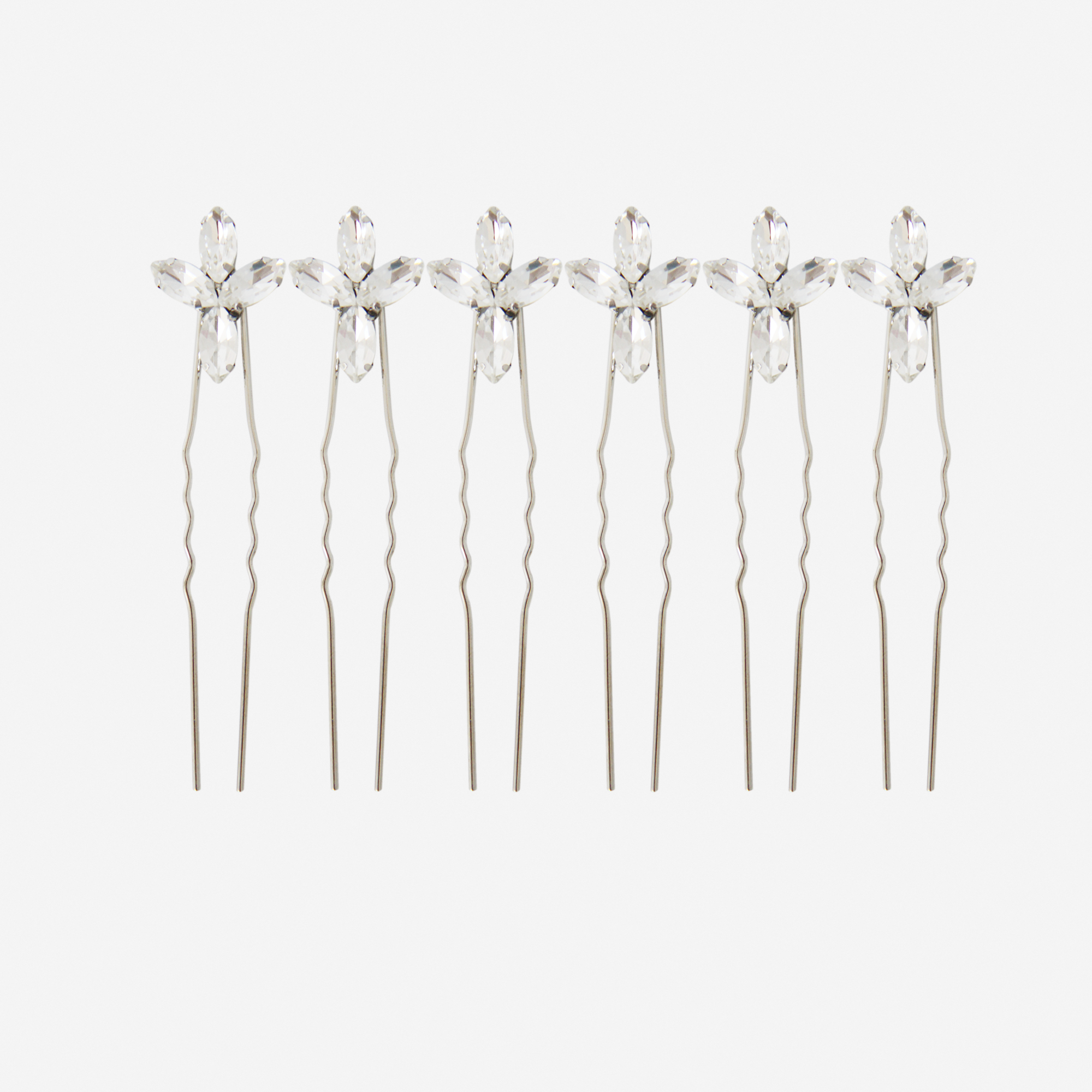 Set of 6 silver hairpins with crystal flower designs on an off white background