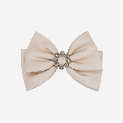Taupe bow hair clip with a decorative crystal center on an off white background