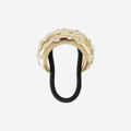 Gold crystal studded hair tie on an off white background