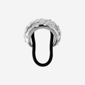 Silver crystal studded hair tie on an off white background