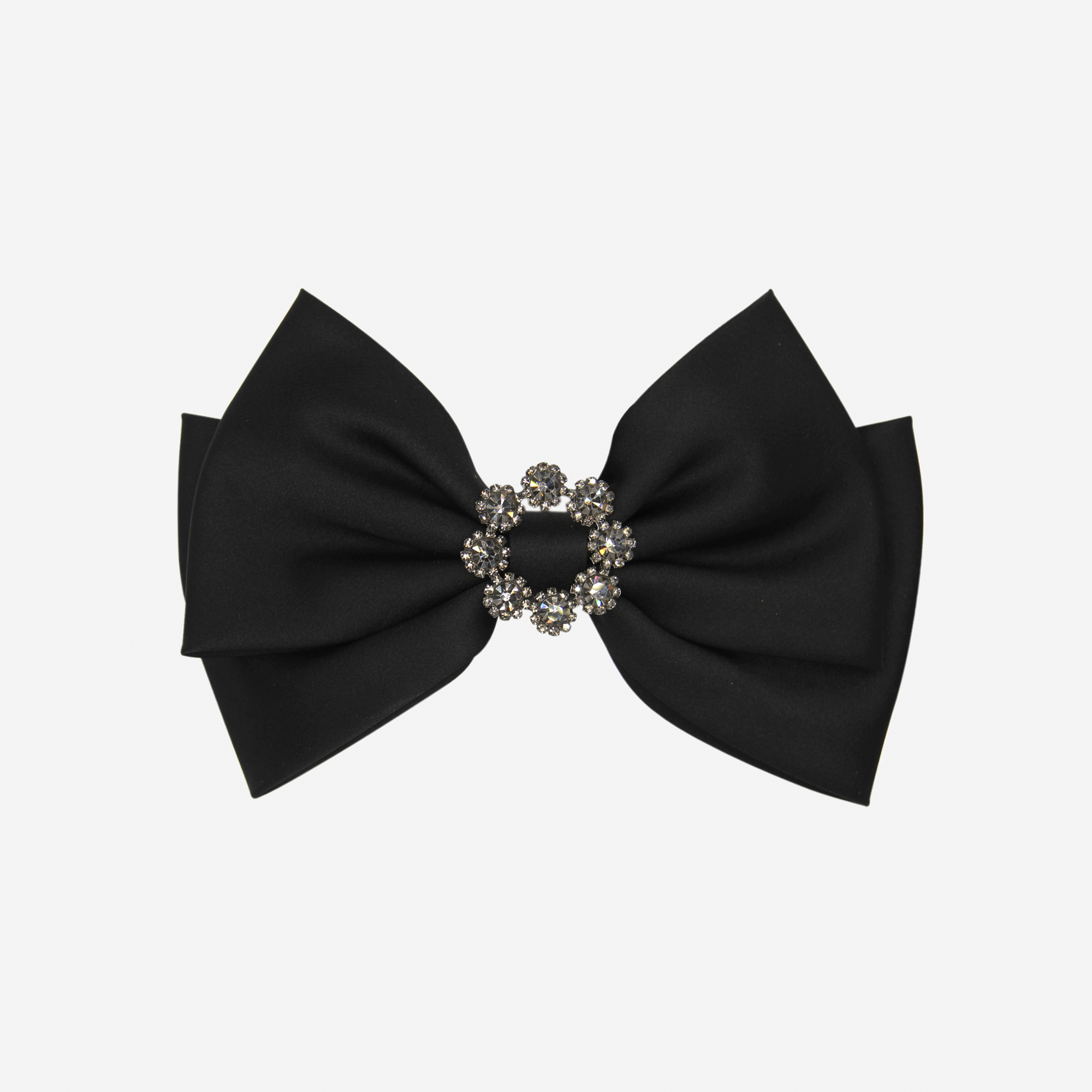 Black bow hair clip with a decorative crystal center on an off white background