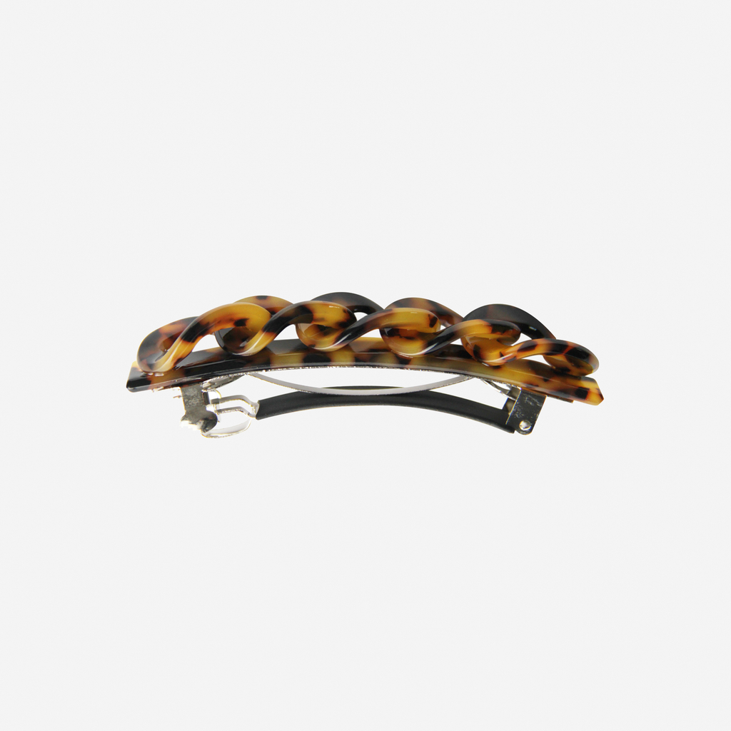 Light Tortoiseshell hair clip with a link design, side view showing the barrette fastening, on an off white background