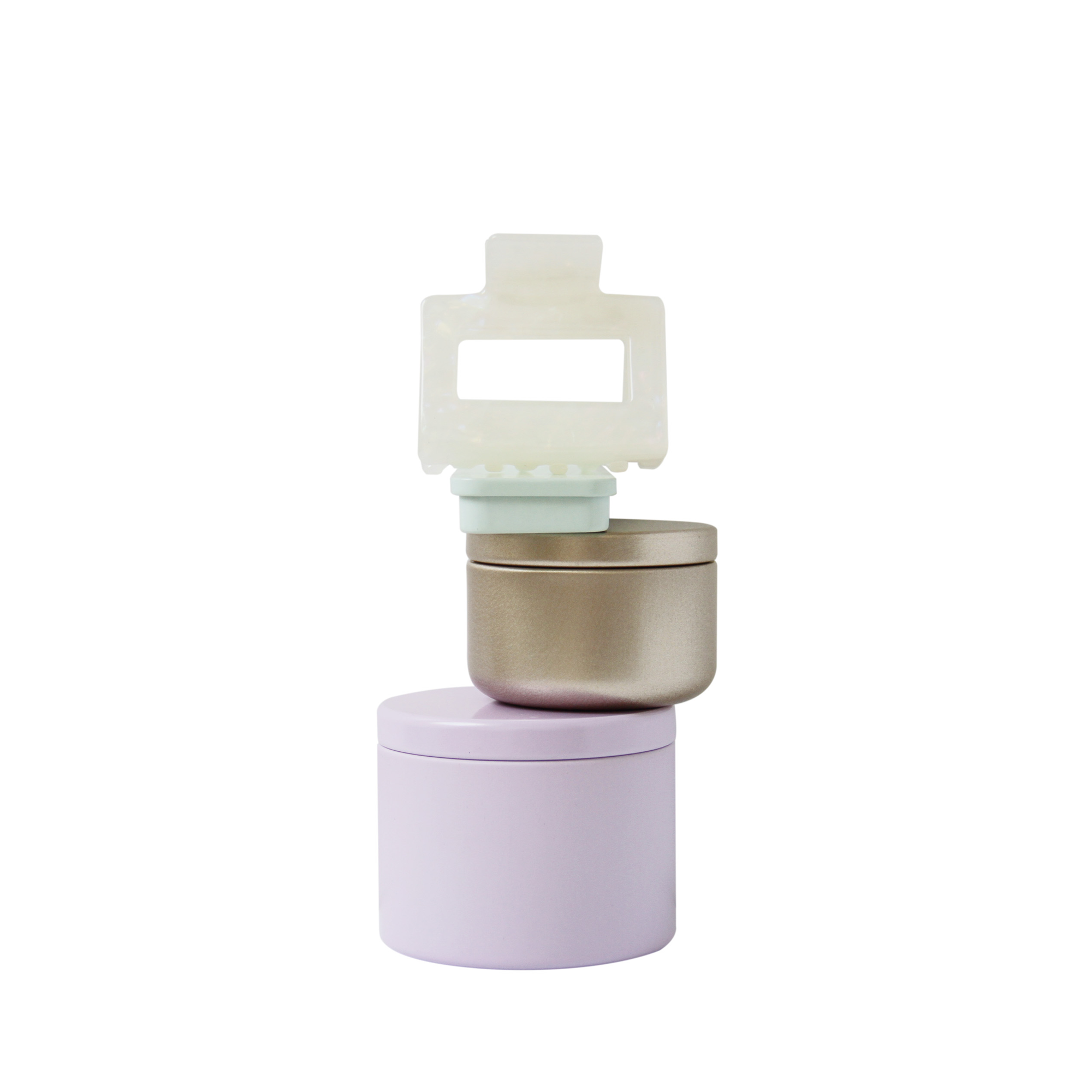Braid & Bow gift set, stack of colourful tins containing hair claws, hair ties and kirby grips with a hair claw balanced on top, on a white background
