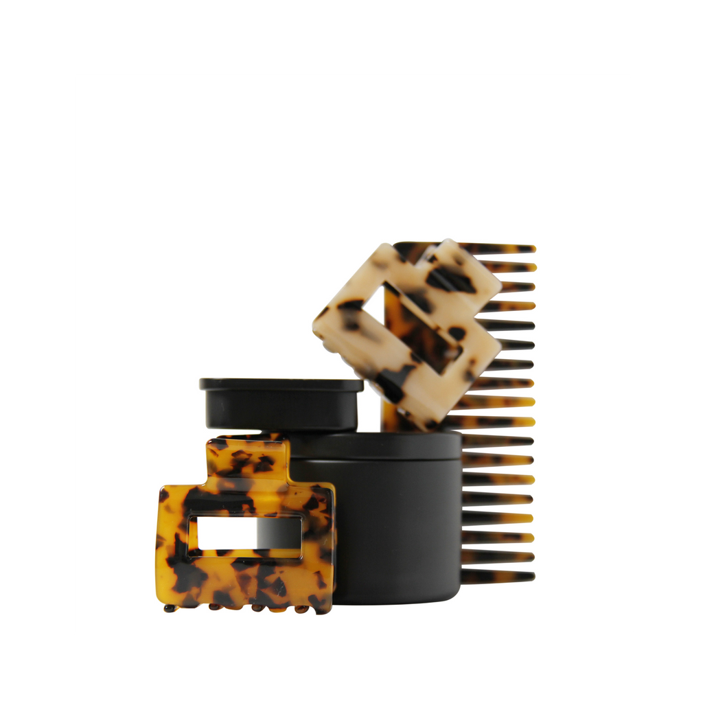 Set of tortoiseshell hair accessories including hair claws and a wide tooth resin hair comb on a white background