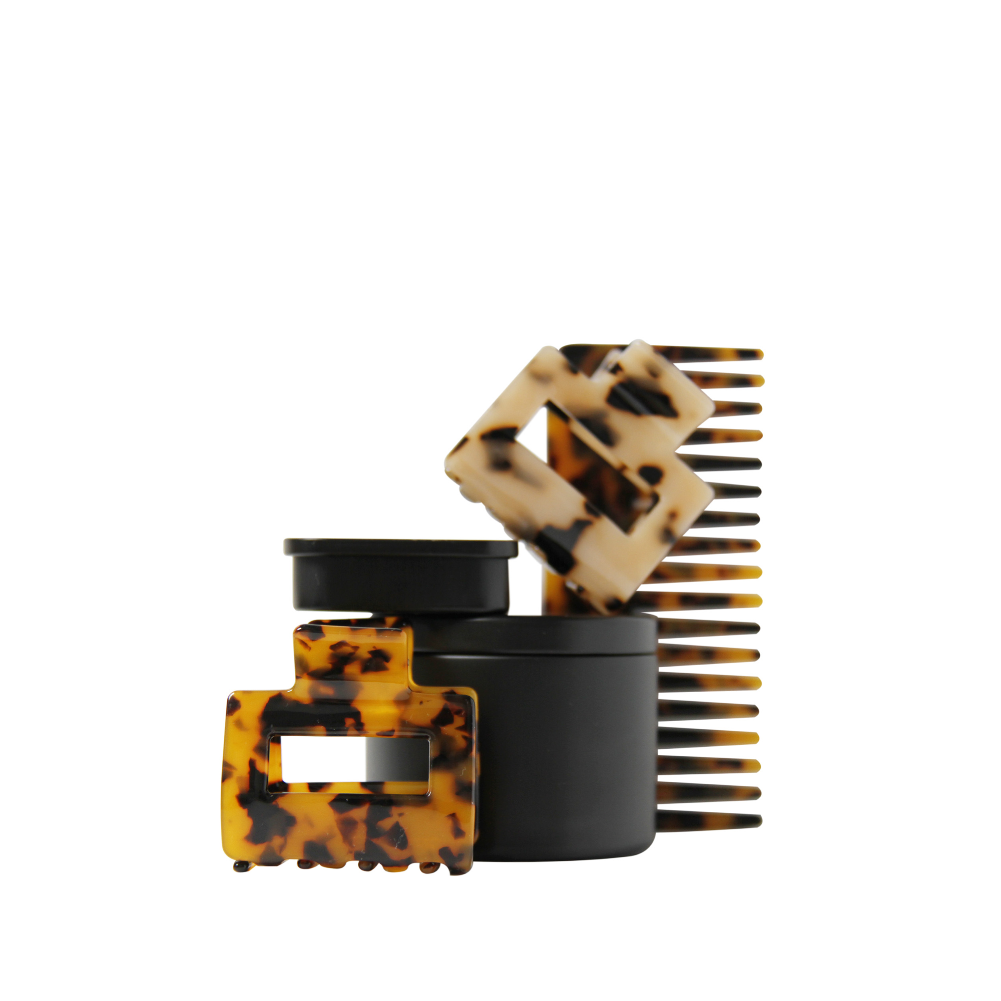 Set of tortoiseshell hair accessories including hair claws and a wide tooth resin hair comb on a white background