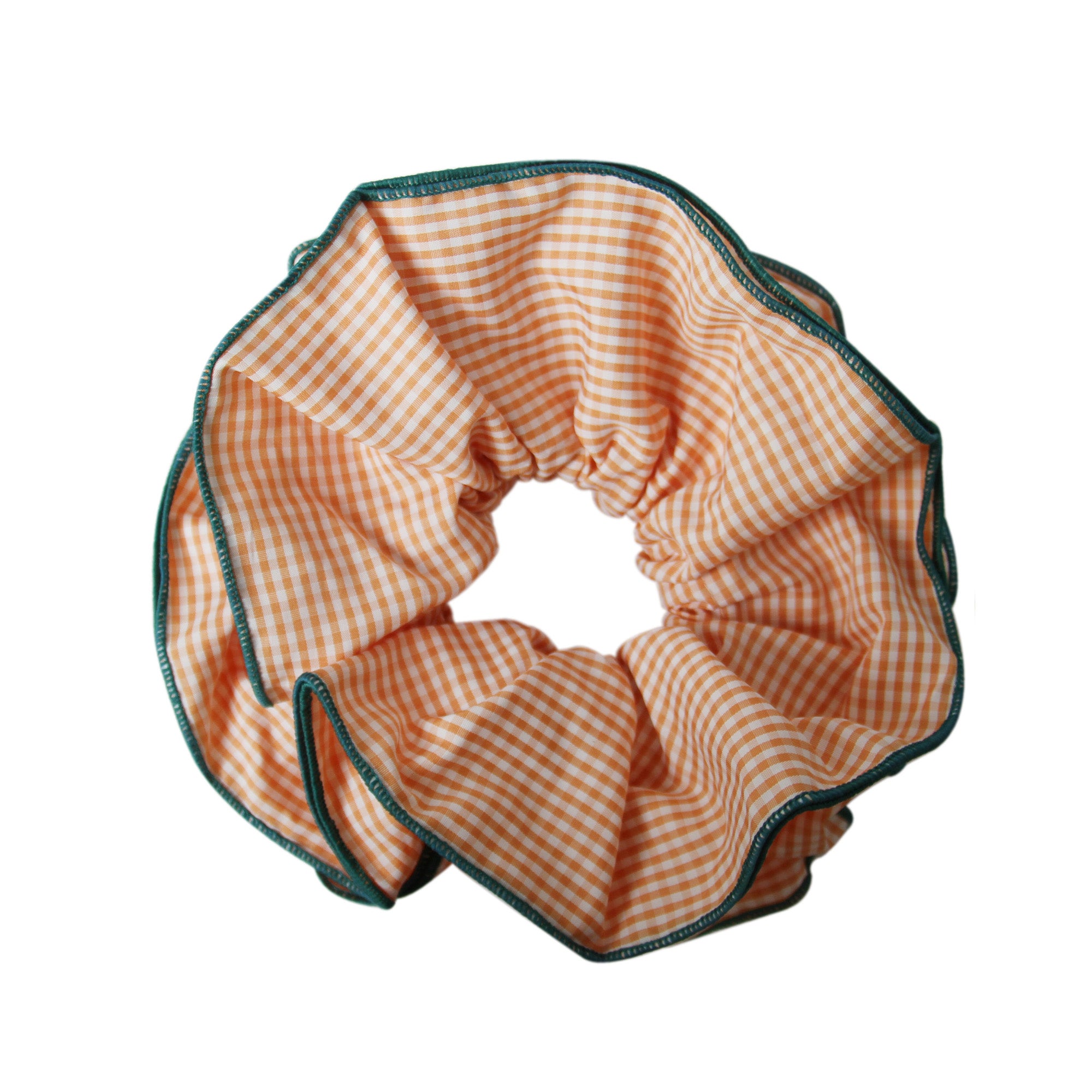 Orange gingham scrunchie with a green trim on a white background
