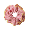 Red gingham scrunchie with a yellow trim on a white background