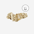 Gold creased hair clip on an off white background, featuring an as seen in Red magazine logo