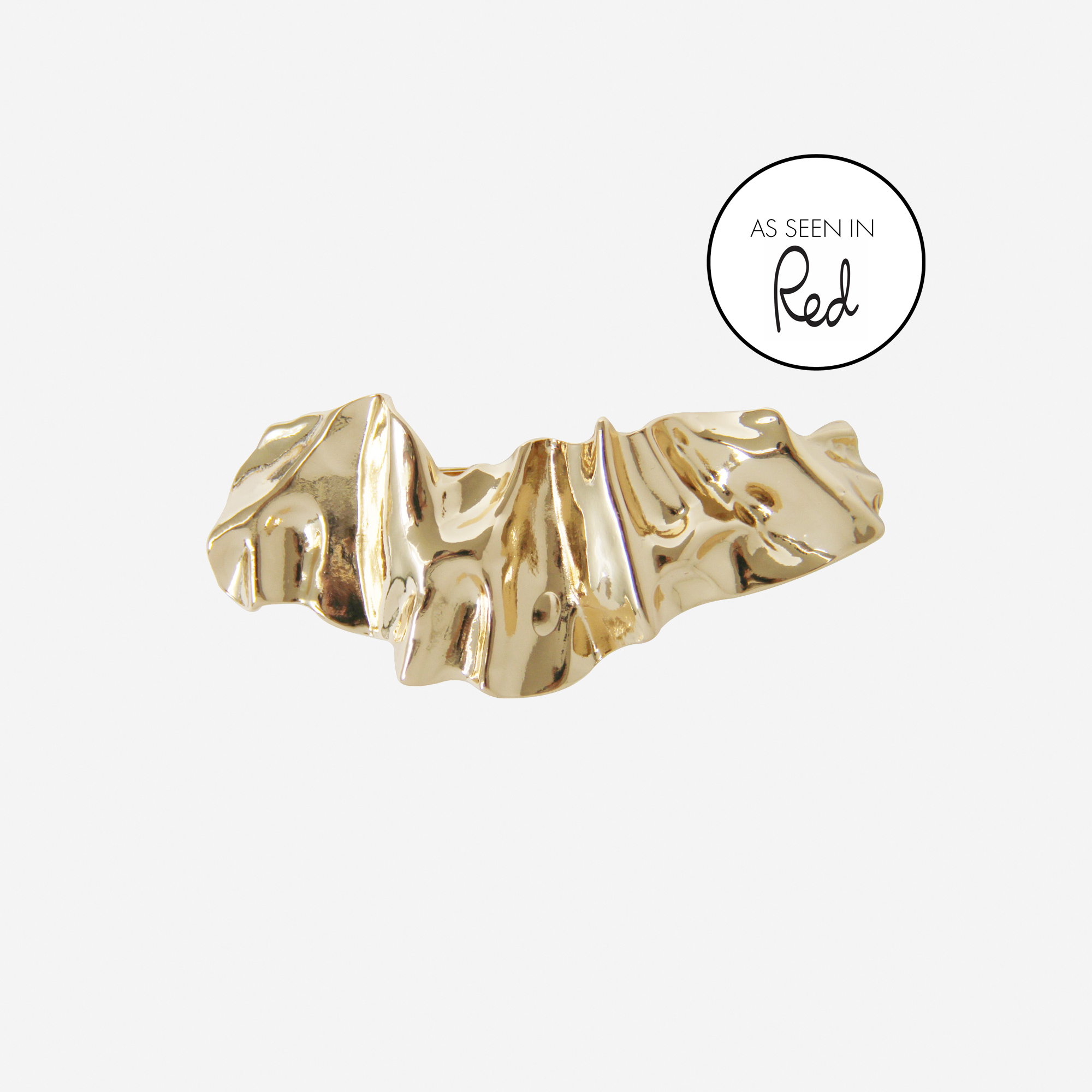Gold creased hair clip on an off white background, featuring an as seen in Red magazine logo