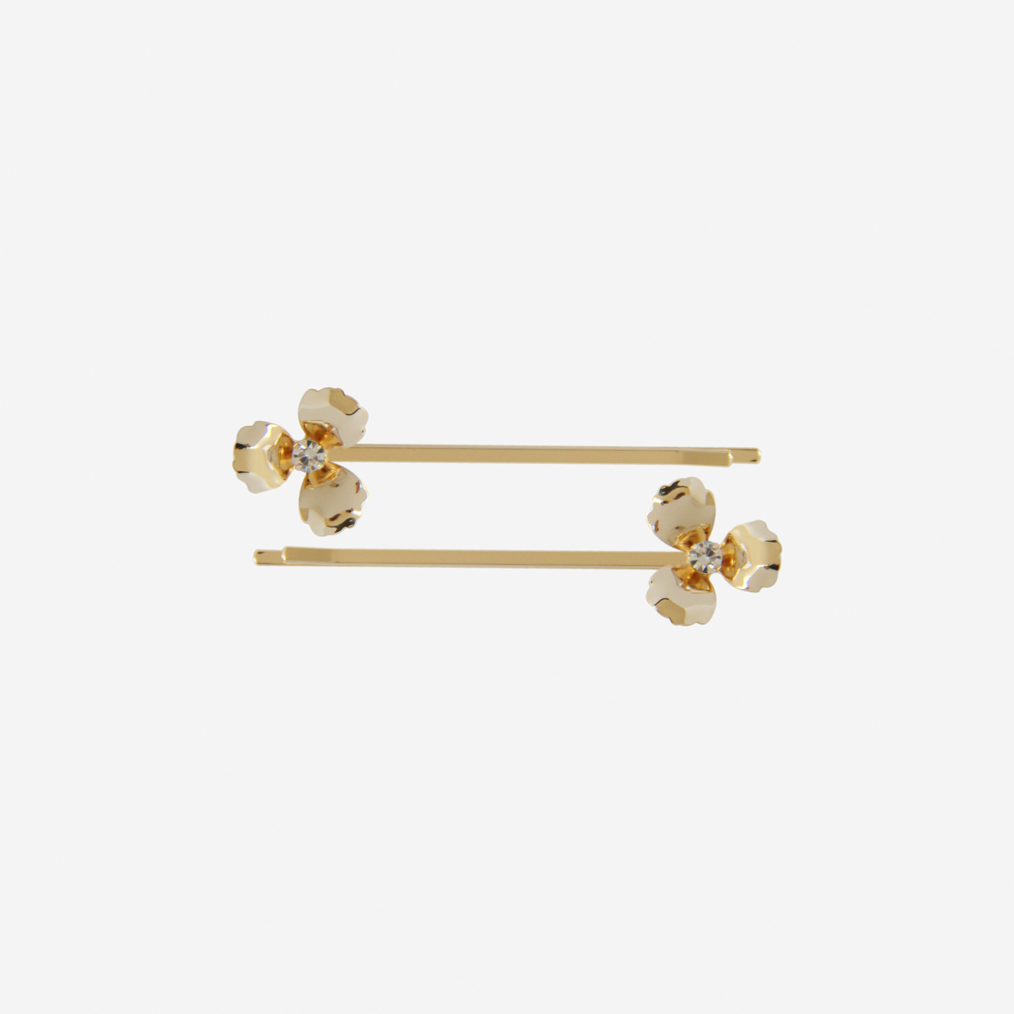 Set of two gold flower hair slides on an off white background