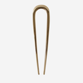 Gold metal french hair pin on an off white background