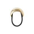 Gold oval ponytail cuff on a black elastic hair tie on a white background