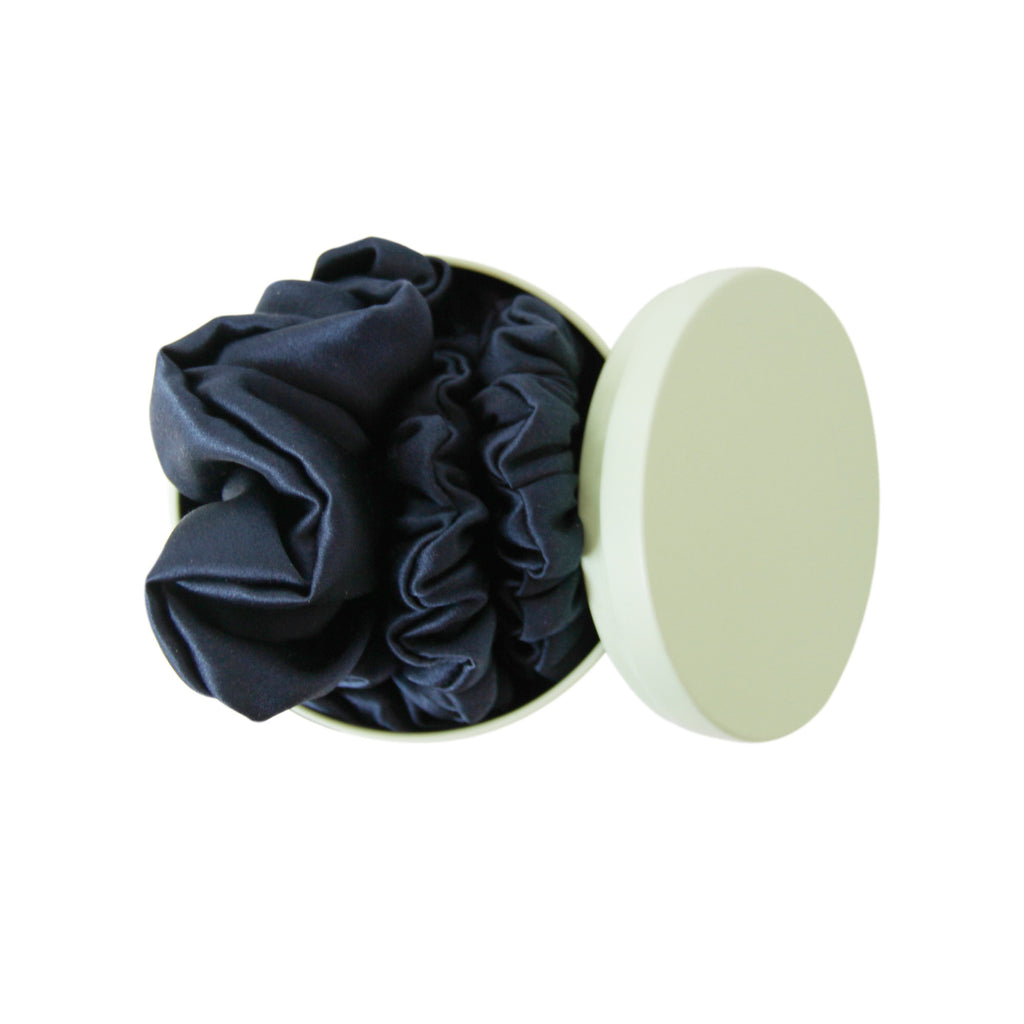 Green Braid & Bow tin with three navy blue silk scrunches on a white background