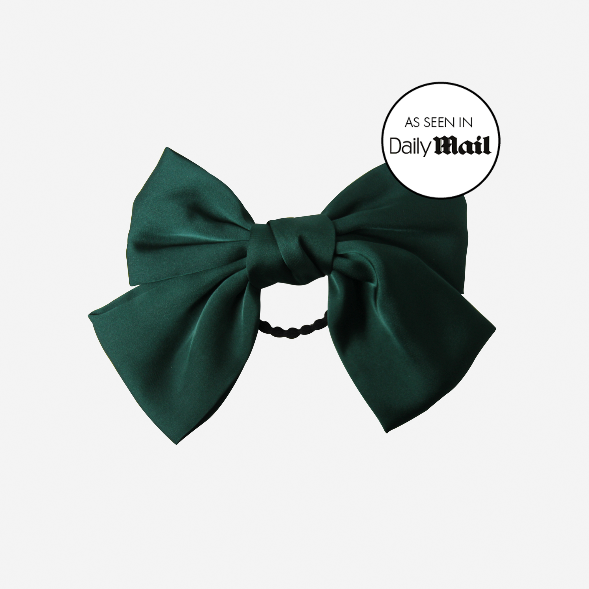Green bow hair tie on an off white background