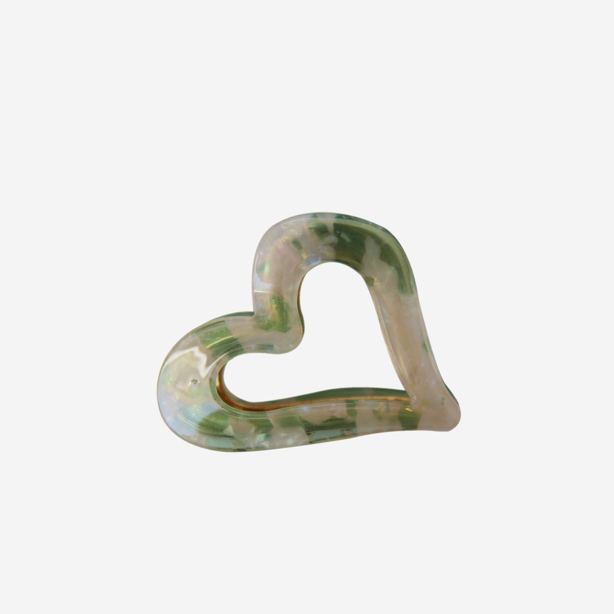 Heart shaped resin hair claw in an green and opal mix colour, on an off white background