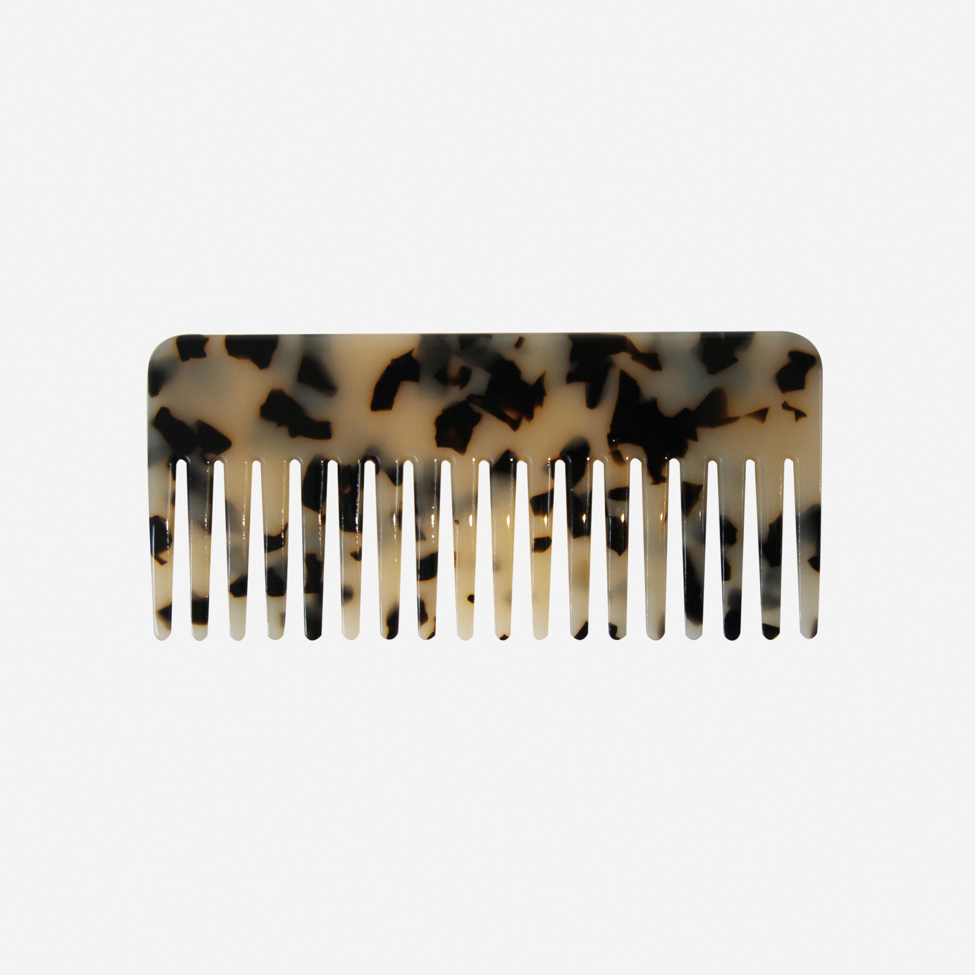 Light Tortoiseshell wide tooth hair comb on an off white background
