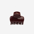 Medium burgundy hair claw on an off white background