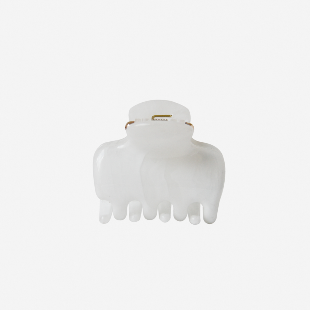 white medium hair claw photgraphed on an off white background