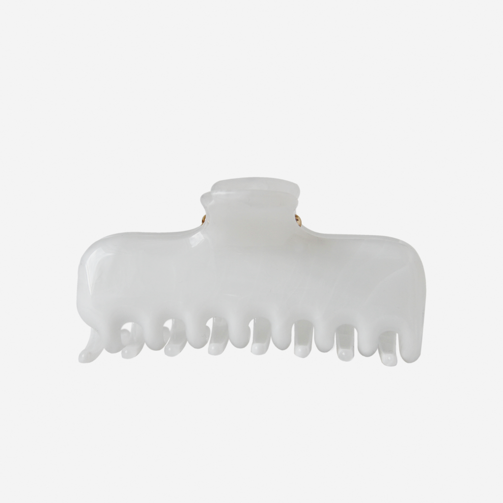 White swirl hair claw on an off white background