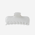 White swirl hair claw on an off white background