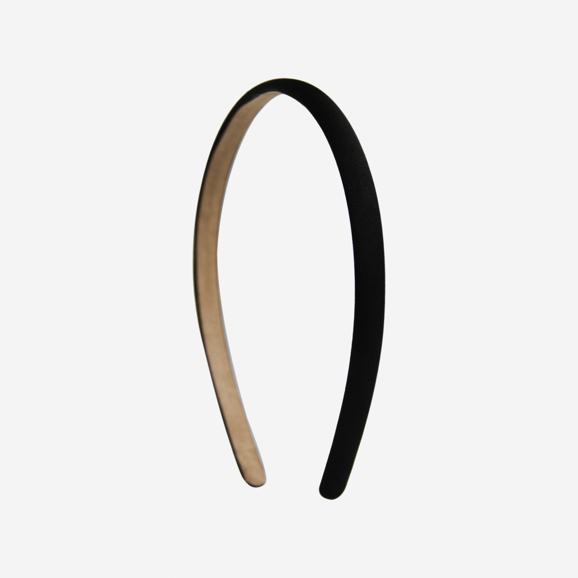 Narrow black headband on an off white background