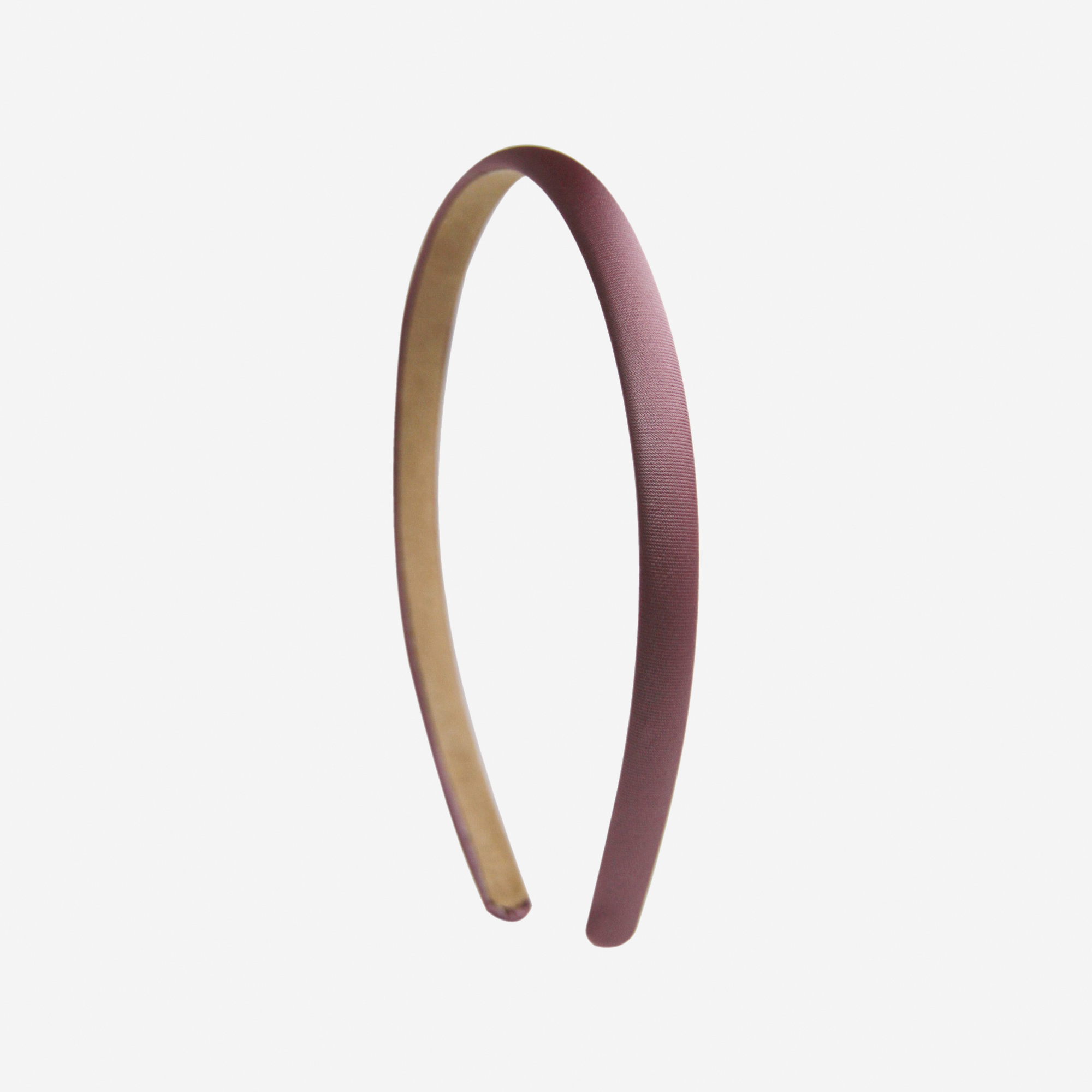 Narrow mauve headband on an off white background