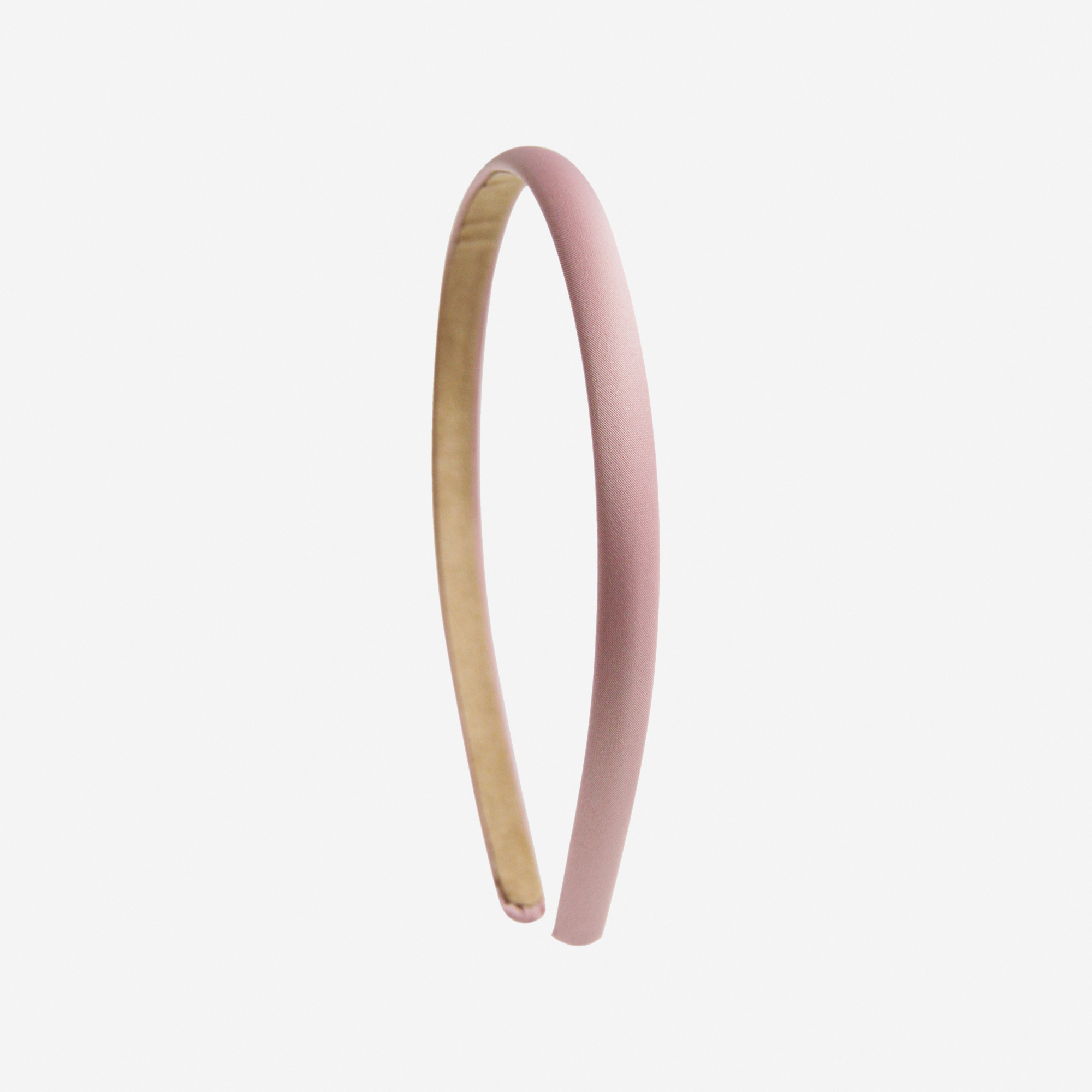 Narrow pink headband on an off white background